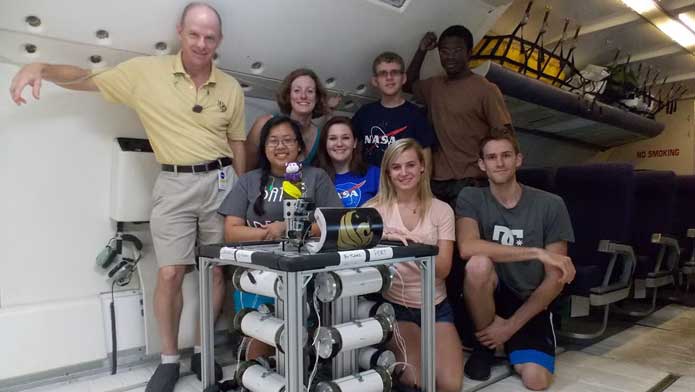 Professor Joshua Colwell, Associate Professor Adrienne Dove and a group of students aboard a Zero-G flight with an experiment built in the Microgravity Center.